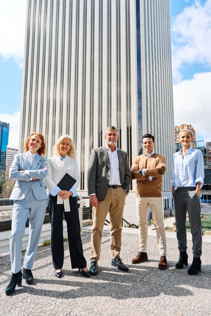 Vertical photo of business people standing together looking at camera