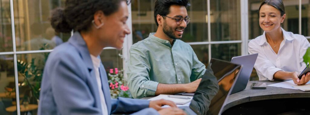 Creative team collaborating on project during meeting in outdoor cafe. Conception of business