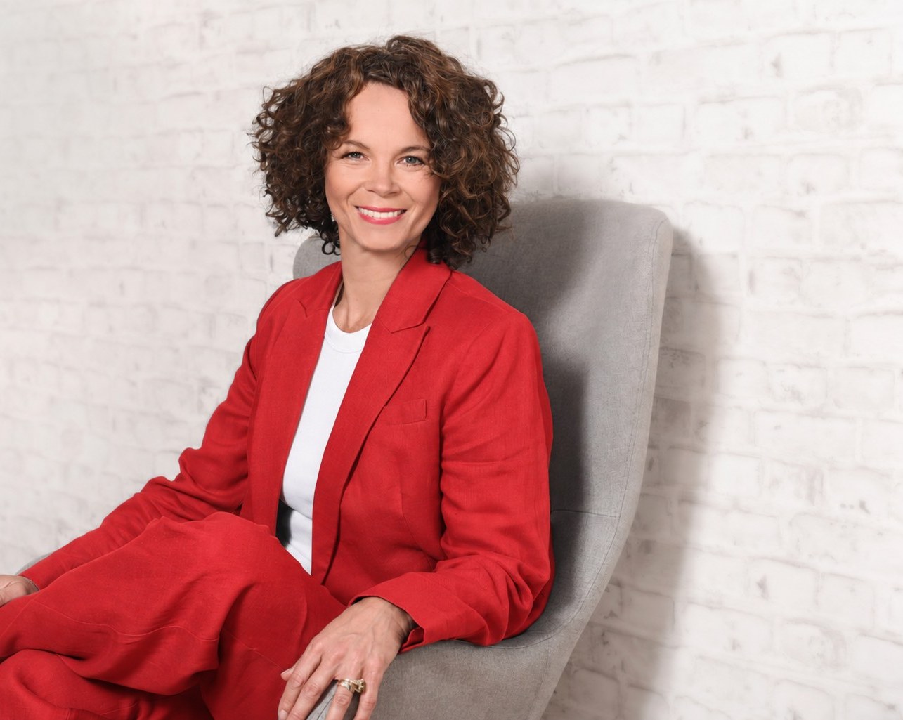 Petra Wagener im roten Anzug, sitzend