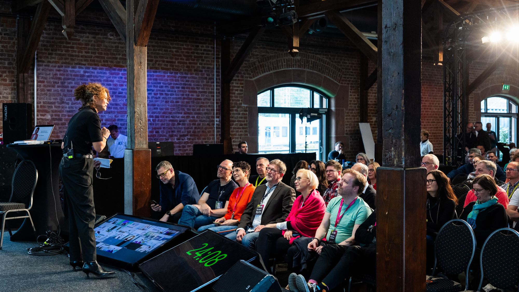 Ein voller Saal hört zu, vorne links spricht Petra Wagener, KI-Summit 2026